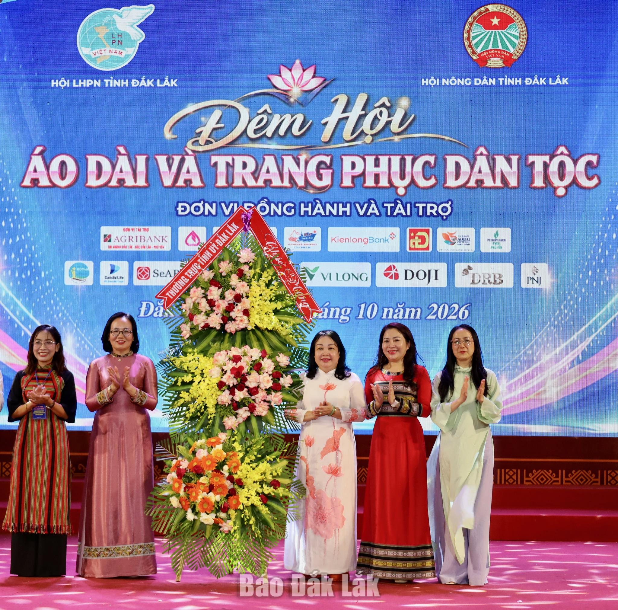 Comrade Cao Thi Hoa An, Member of the Party Central Committee, Standing Deputy Secretary of the Provincial Party Committee and Chairwoman of the Provincial Peoples Council, presenting flowers to congratulate the Ao Dai alongside Ethnic Costume Night, co-organised by the Provincial Women’s Union and the Provincial Farmers’ Union.