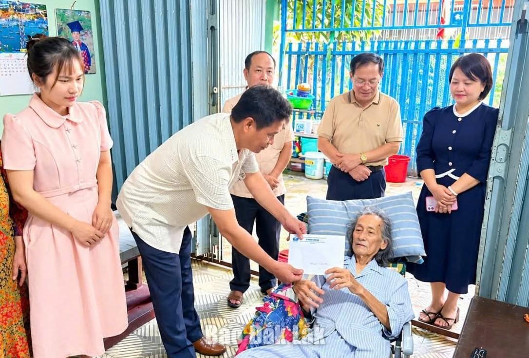 Đại diện Ban Vận động Quỹ vì người nghèo phường Tân An trao tiền hỗ trợ cho gia đình ông Nguyễn Thành Đạt.