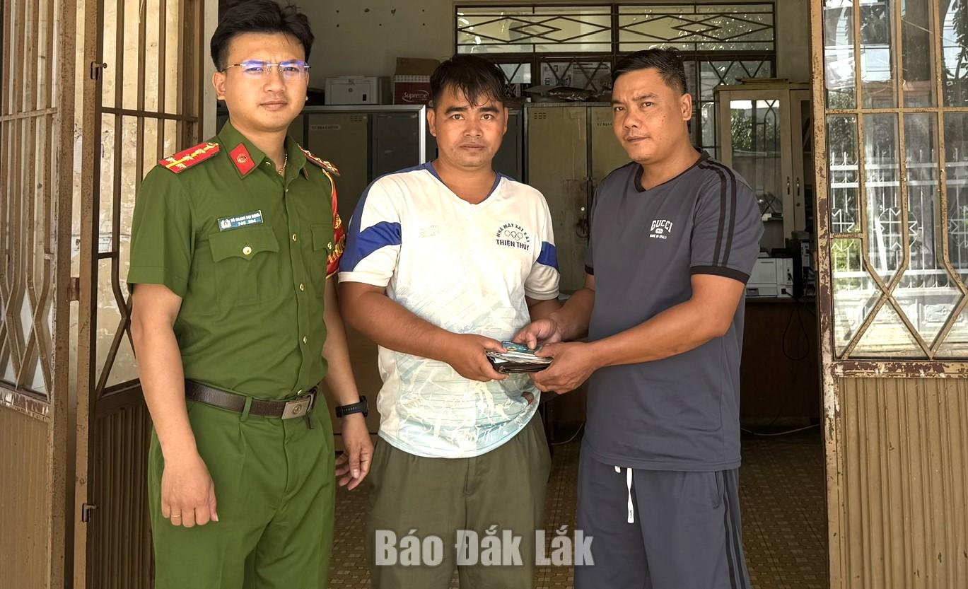 Cán bộ Công an xã Đắk Phơi phối hợp với anh Phạm Đắc Chấn trao trả lại tài sản cho người đánh rơi.