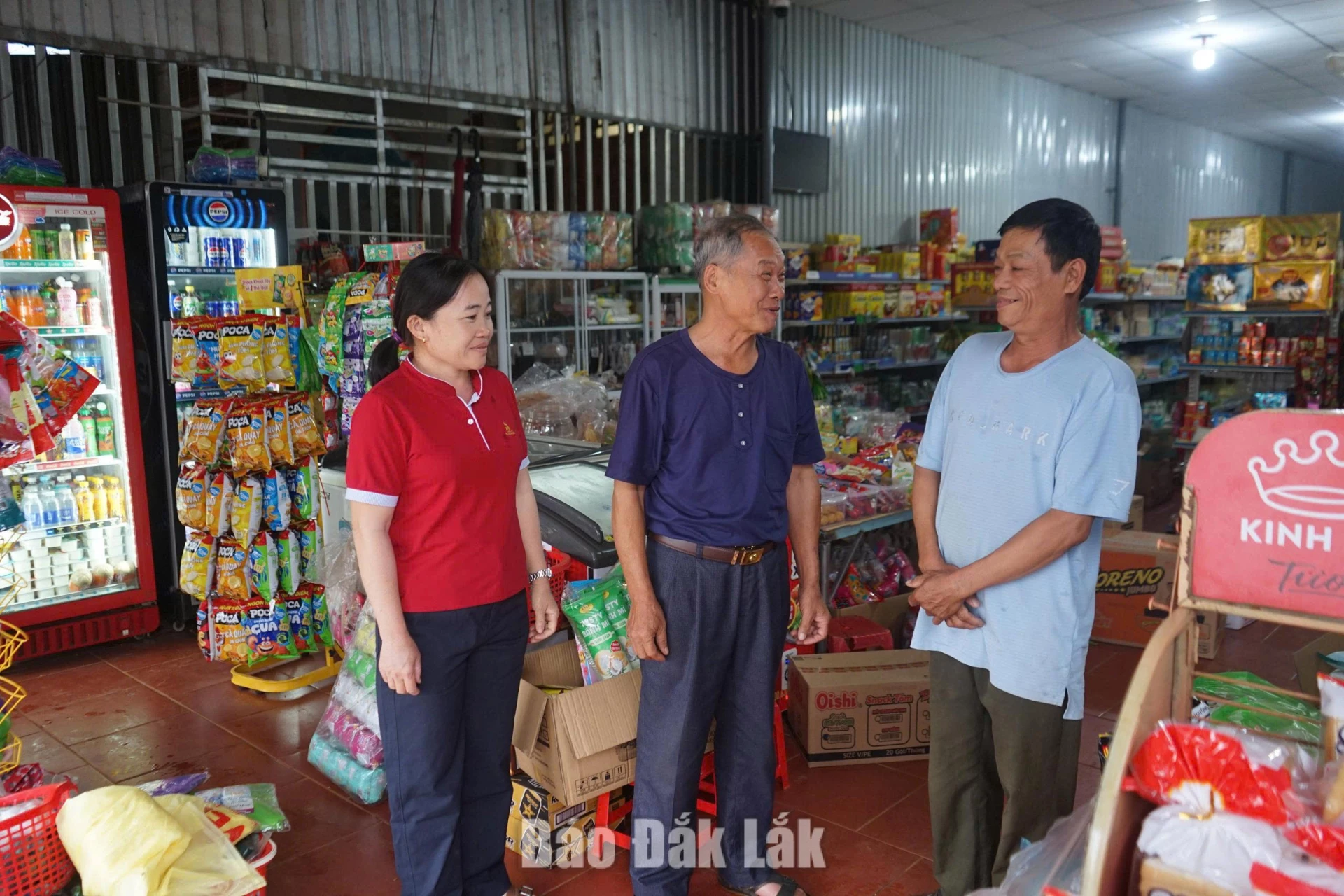 Ông Viết (ở giữa) cùng cán bộ Phòng Văn hóa - Xã hội, xã Tam Giang tuyên truyền, vận động người dân thực hiện các quy định của pháp luật trong hoạt động kinh doanh buôn bán.