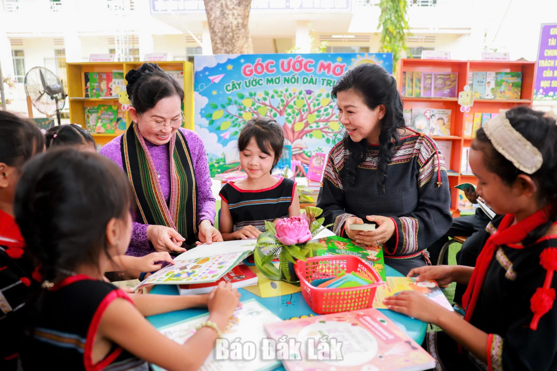 Các đại biểu trò chuyện với học sinh tại góc đọc sách.