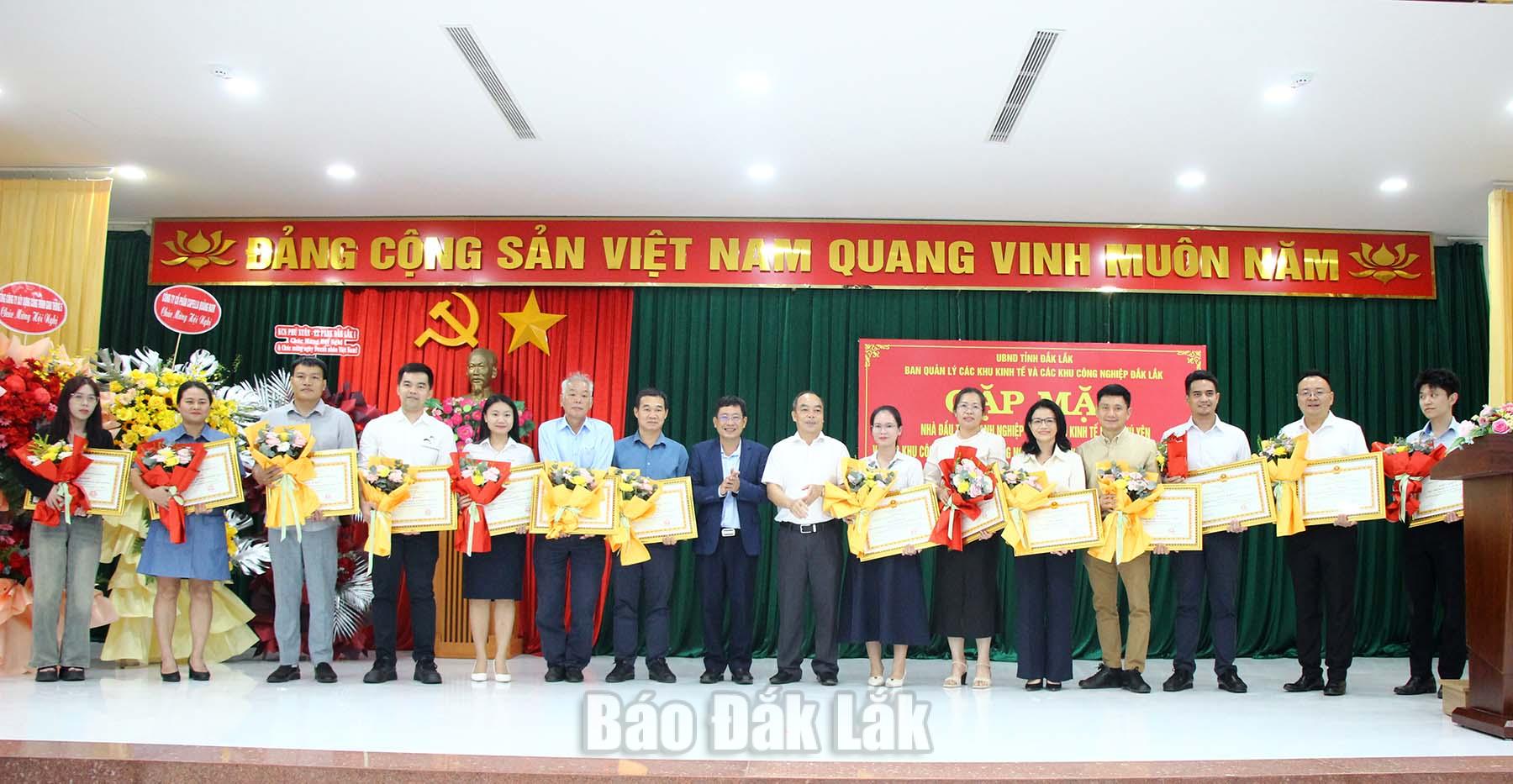Leaders of the Dak Lak Economic Zone and Industrial Park Management Board presenting certificates of merit to enterprises.