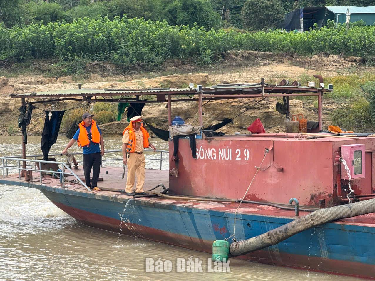 Cán bộ Đội Cảnh sát đường thủy số 1 kiểm tra điều kiện an toàn của tàu vận chuyển khoáng sản trên sông. 
