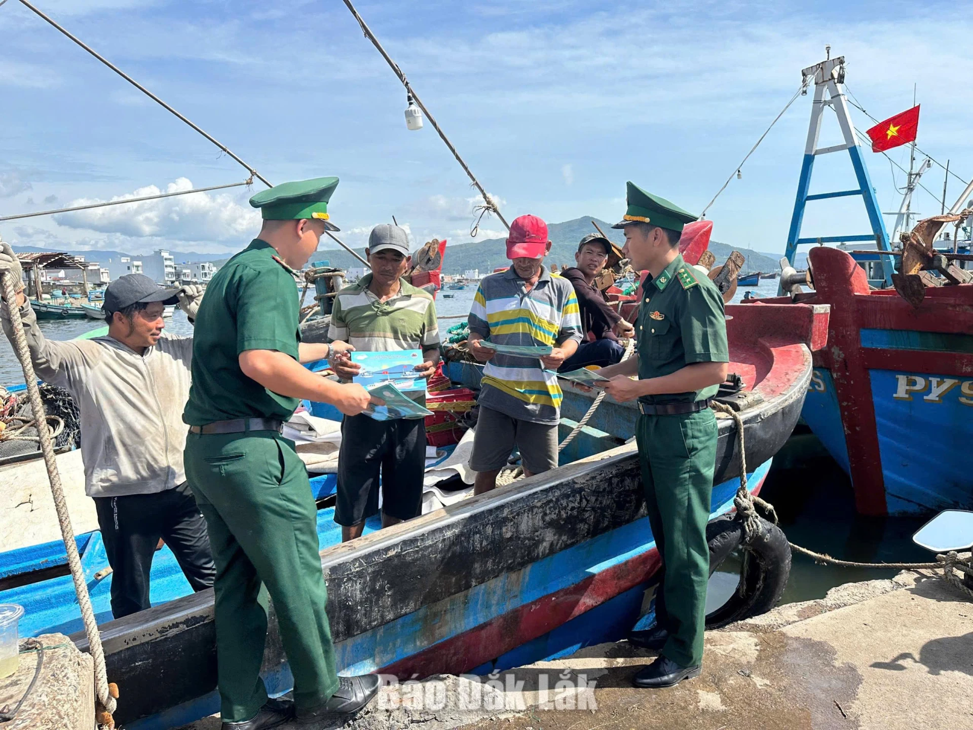 Lực lượng bộ đội biên phòng phát tờ rơi tuyên truyền chống khai thác IUU cho ngư dân phường Xuân Đài.
