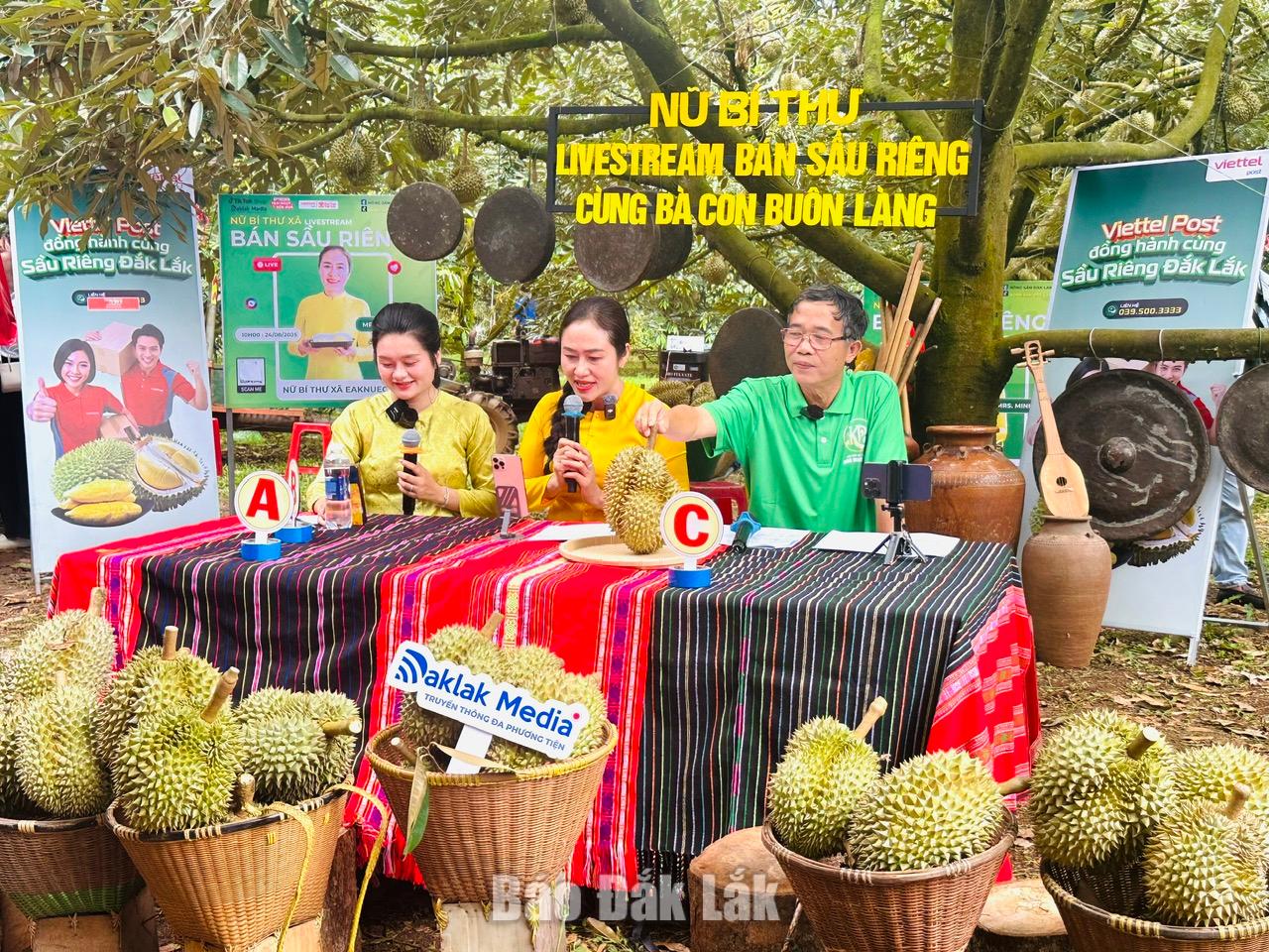 Bí thư Đảng ủy xã Ea Knuếc Ngô Thị Minh Trinh (giữa) cùng bà con buôn làng mở phiên livestream bán sầu riêng. 
