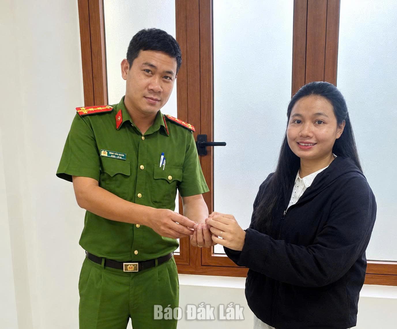 Chị Siu H' Ha (phải) trao tài sản nhặt được cho Công an xã Sơn Hòa.