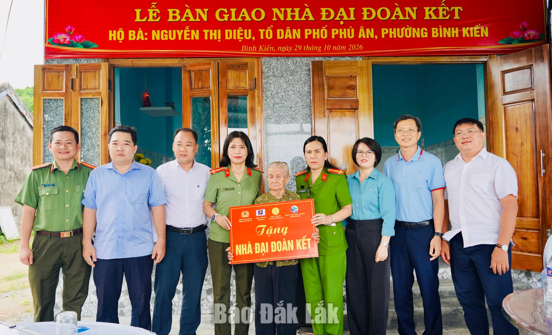 Lãnh đạo địa phương và các đơn vị tài trợ trao tiền hỗ trợ xây nhà cho bà 