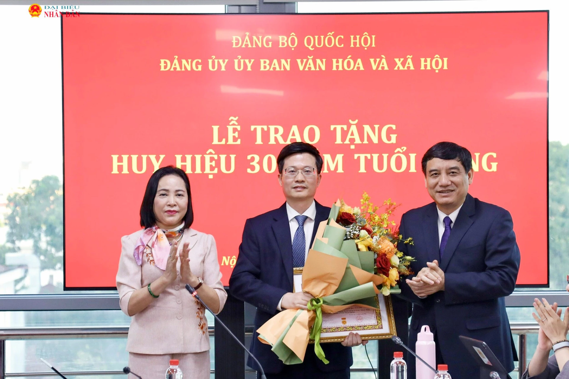 Phó Chủ tịch Quốc hội Nguyễn Thị Thanh, Chủ nhiệm Ủy ban Văn hóa và Xã hội Nguyễn Đắc Vinh tặng hoa chúc mừng đồng chí Đỗ Chí Nghĩa. Ảnh: daibieunhandan.vn