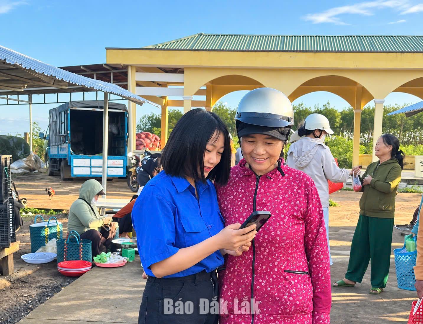 Thành viên Tổ công nghệ số cộng đồng thôn Phong Hậu hướng dẫn người dân sử dụng các ứng dụng số trên điện thoại. 
