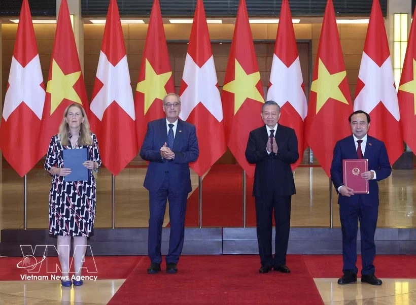 General Secretary of the Communist Party of Vietnam Central Committee and President To Lam (second from right) and Swiss President Guy Parmelin (second from left) witness the exchange of cooperation documents between ministries and agencies. (Photo: VNA)
