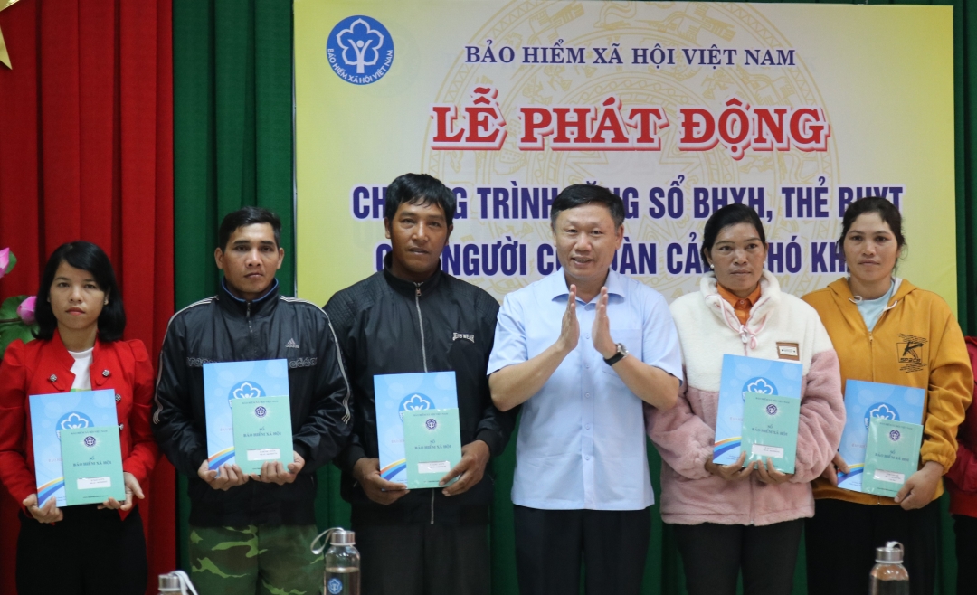Giám đốc BHXH tỉnh Nguyễn Khắc Tuấn tặng sổ BHXH cho người dân. 