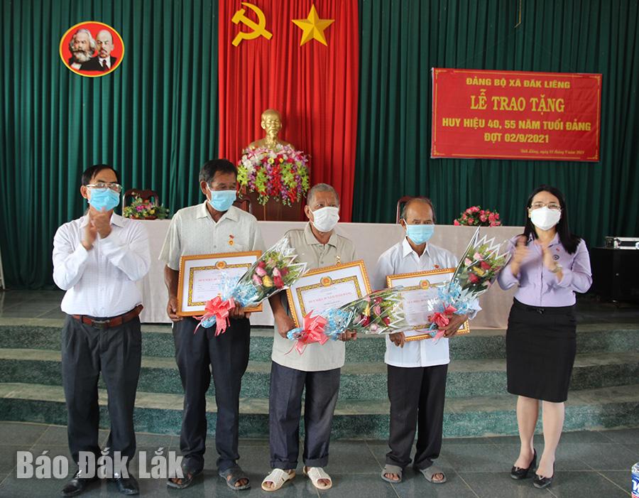 Phó Bí thư Thường trực Huyện ủy Lắk Đào Thị Thanh An (bìa phải) trao huy hiệu Đảng tặng các đảng viên thuộc Đảng bộ xã Đắk Liêng.