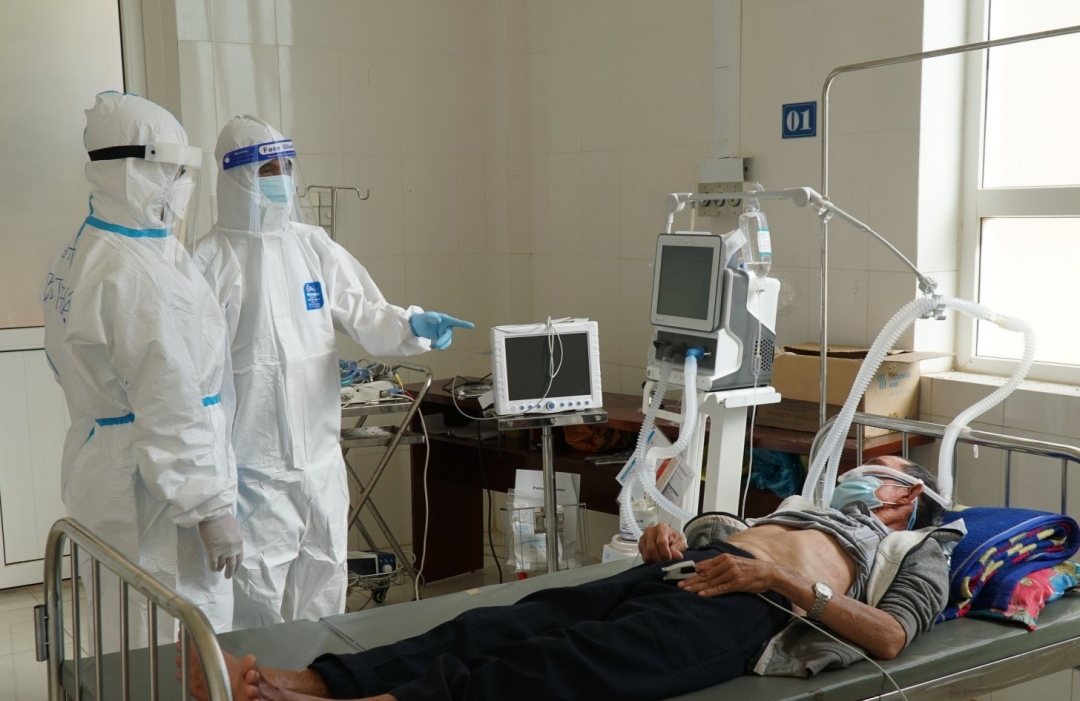 Y bác sĩ Trung tâm y tế huyện Krông Búk trao đổi về tình trạng sức khỏe của bệnh nhân COVID-19 tại khu vực điều trị.