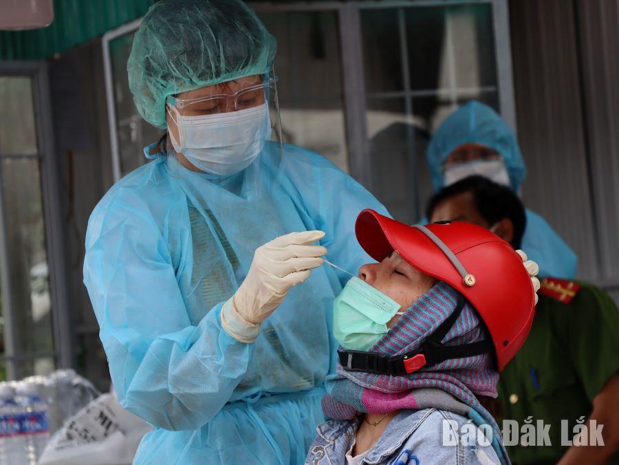 Nhân viên y tế lấy mẫu xét nghiệm SARS-CoV-2 cho người dân tại chợ đầu mối Tân Hòa, phường Tân Hòa.