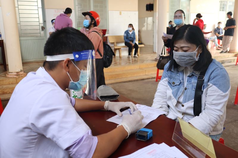Nhân viên y tế lấy thông tin của người dân trước khi tiêm vắc xin phòng COVID-19.