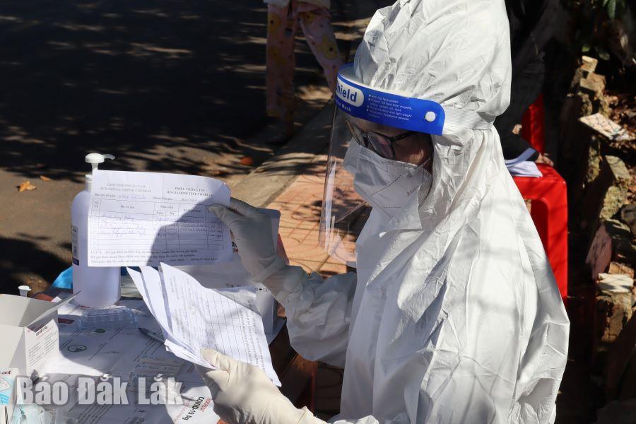 Nhân viên y tế rà soát danh sách hộ dân thực hiện test nhanh SARS-CoV-2.