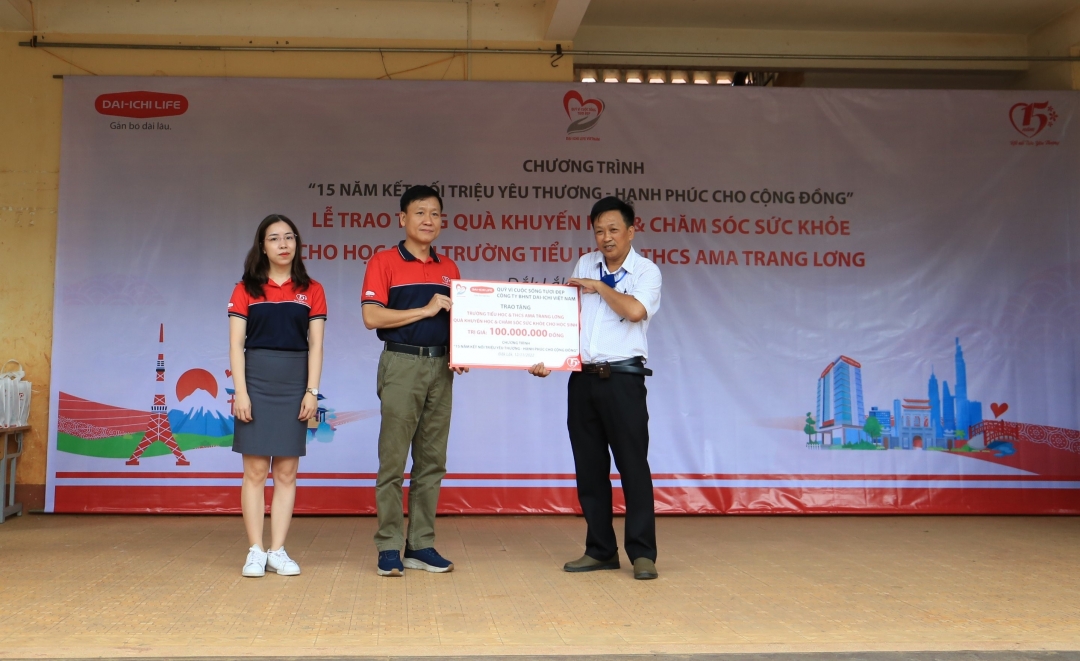 Ông Trần Đình Quân - TGĐ Dai-ichi Life VN trao tấm séc tượng trưng 100 triệu đồng cho thầy Trần Văn Sơn – Hiệu trưởng trường Tiểu học và THCS Ama Trang Lơng