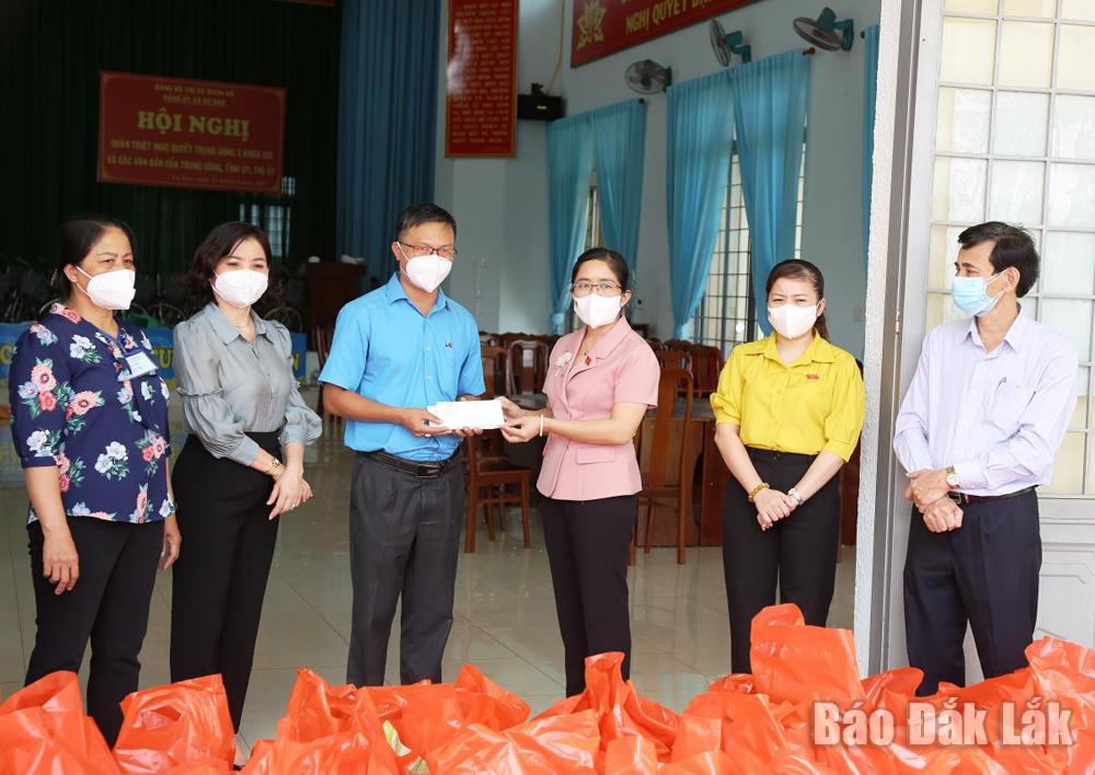 Đoàn công tác trao quà ủng hộ người dân buôn Kwang thông qua lãnh đạo xã Cư Bao.