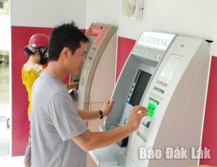 Khách hàng giao dịch tại máy ATM mới được trang bị tại Agribank Krông Ana.