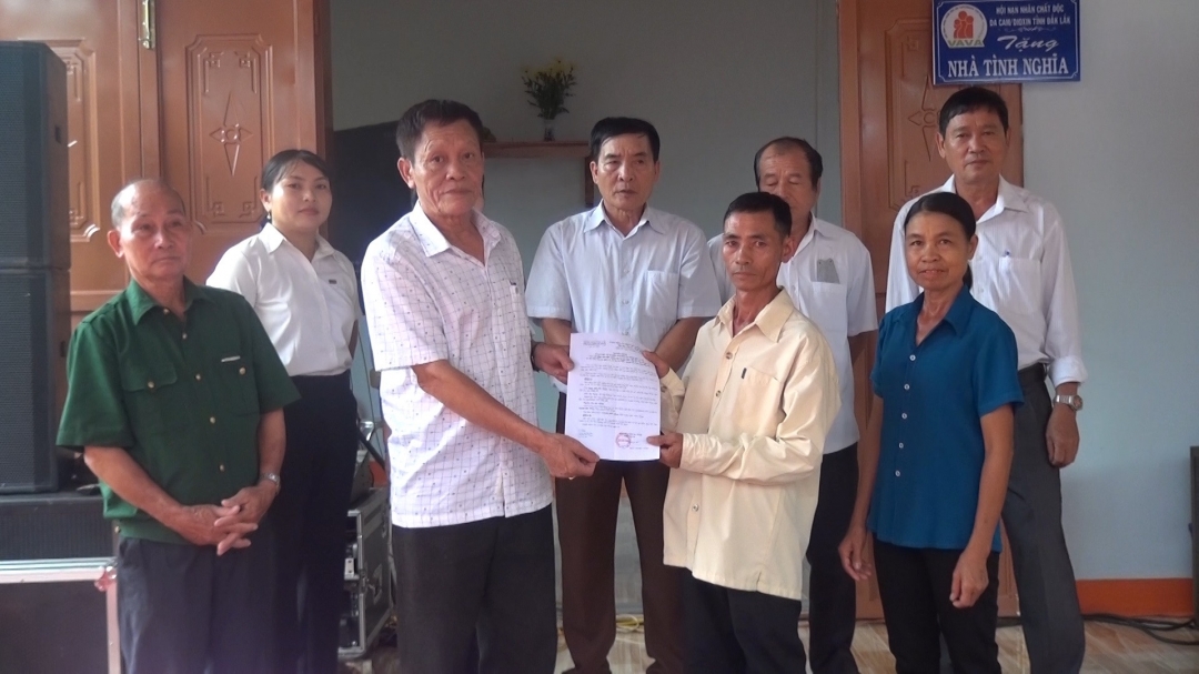 Đại diện Hội Nạn nhân chất độc da cam tỉnh Đắk Lắk và các ban ngành địa phương tặng quà cho gia đình ông Thoan nhân dịp về nhà mới