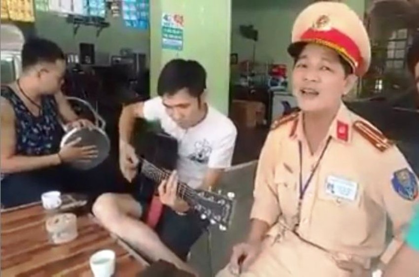Trung tá Tuấn vui vẻ hát bài Hà Nội mùa này vắng những cơn mưa cùng người dân. Ảnh cắt từ clip/nguồn Internet
