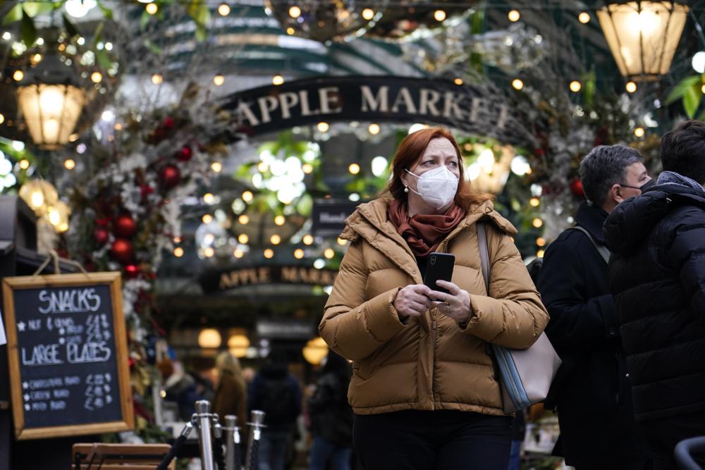 Người phụ nữ đeo khẩu trang tại một khu chợ ở London (An) ngày 16/12/2021. Ảnh: AP