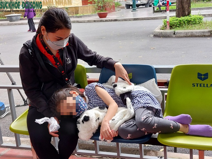 Một em nhỏ được mẹ đưa đi khám bệnh tại Khu khám và thu dung người bệnh COVID-19, BV Thanh Nhàn.