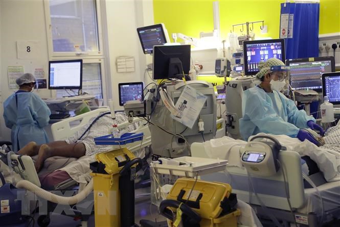 Nhân viên y tế điều trị cho bệnh nhân COVID-19 tại một bệnh viện ở London, Anh. (Ảnh: AFP/TTXVN)