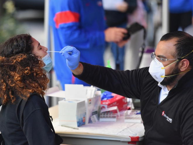 Nhân viên y tế lấy mẫu xét nghiệm COVID-19 cho sinh viên tại trung tâm y tế Brooklyn ở New York, Mỹ. Ảnh: AFP/TTXVN