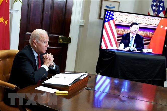 Tổng thống Mỹ Joe Biden (trái) và Chủ tịch Trung Quốc Tập Cận Bình (trên màn hình) trong cuộc hội đàm thượng đỉnh trực tuyến, tại Washington DC., ngày 15/11/2021. (Ảnh: AFP/TTXVN)