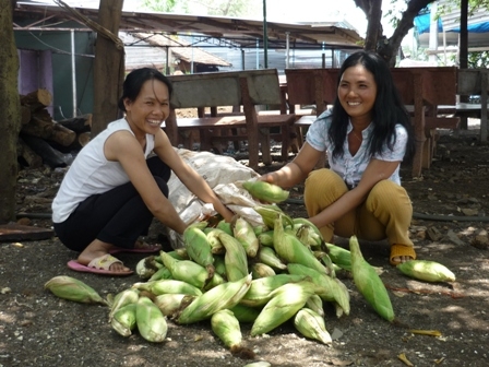 Chị Thu (bên phải) cùng em gái chuẩn bị bắp để luộc.