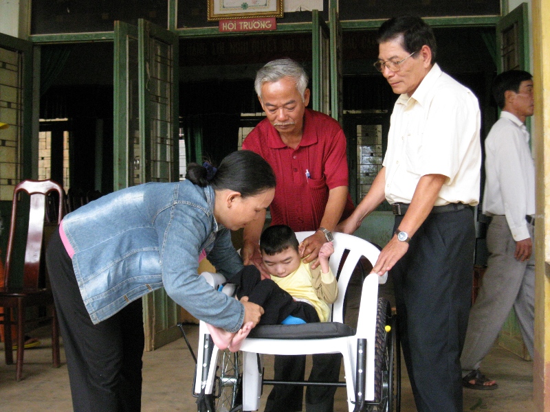 Đại diện Báo Dak Lak trao xe lăn tặng các cháu bị bại não và tật nguyền.