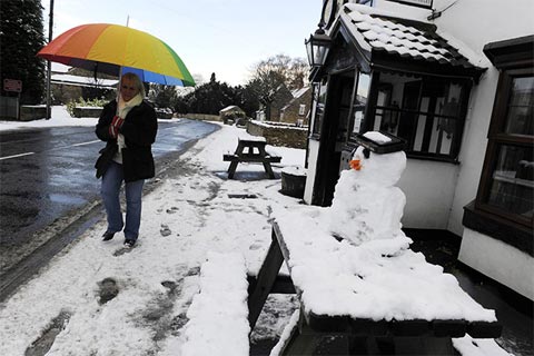 Một phụ nữ co ro trong cái rét trên một con phố tại Sutton-under-Whitestonecliffe, North Yorkshire