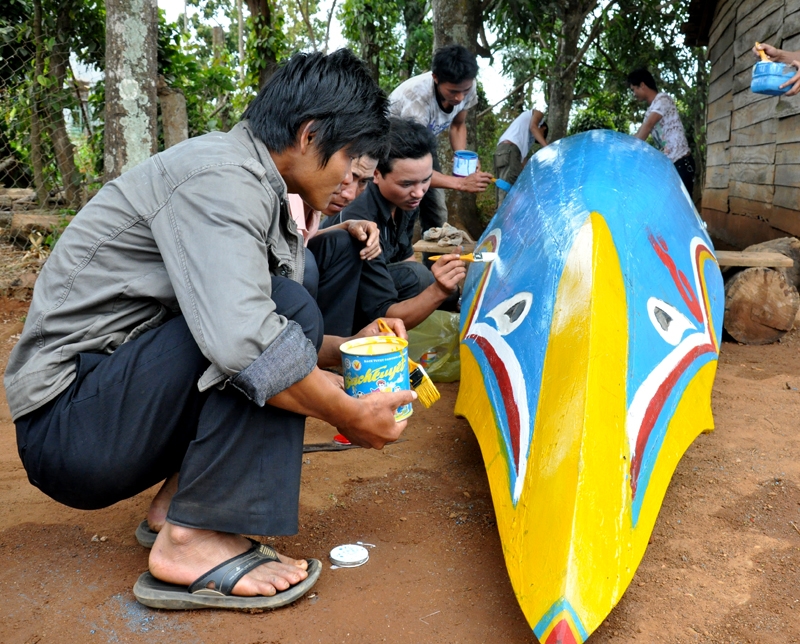 Các thành viên đội đua Thanh niên xã Bình Hòa đang cùng nhau sơn lại thuyền