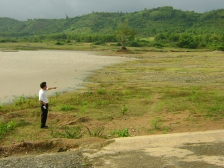 Cán bộ Phòng Nông nghiệp và Phát triển nông thôn huyện Krông Pak kiểm tra mực nước ở đập Ea Yiêng (huyện Krông Pak)