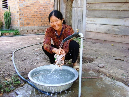 Niềm vui của chị Nông Thị Lý (thôn 14, xã Ya T'mốt) khi công trình cấp nước tập trung mới được đưa vào vận hành.