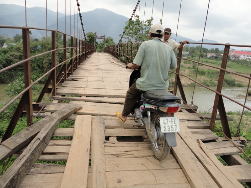 Hai đầu cầu treo Cư Đ’răm đã bị hư hỏng, để người dân đi lại, buôn phải mang gỗ ra lắp ghép tạm bợ