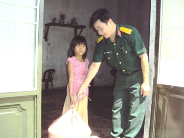 Đại diện Ban Chỉ huy Quân sự huyện Buôn Đôn trao số gạo cho gia đình chị em H’Cát Tơr.