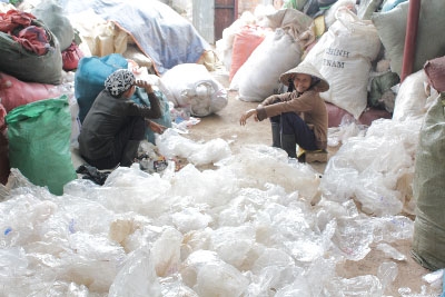 Các công nhân không được trang bị dụng cụ bảo trợ lao động ngày ngày phải ngồi phân loại các bao bì dạng rác thải này