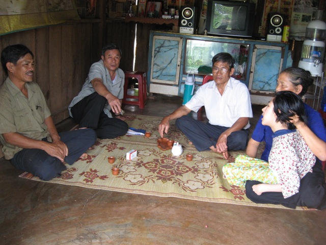 Vợ chồng anh Lê Đình Tôn (huyện Cư M’gar) và bé Thư - đứa con bị nhiễm chất độc da cam - ngồi ôn lại kỷ niệm năm xưa với những đồng đội của mình.