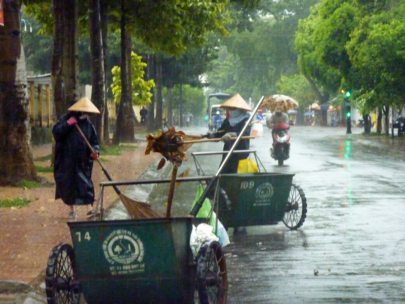 Công nhân vệ sinh vẫn cần mẫn làm việc trong mưa