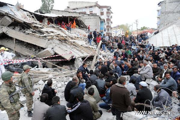 Người dân đang nghe ngóng thông tin về việc tìm kiếm các nạn nhân của trận động đất. Ảnh: Xinhua