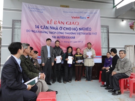 Đại diện Vietinbank Dak Lak (ngoài cùng bên trái) trao quyết định bàn giao nhà cho các hộ nghèo