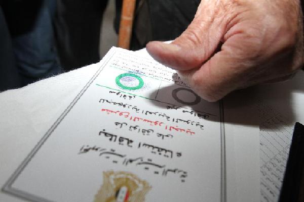 Một người cao tuổi đang điểm chỉ trên lá phiếu của mình tại một trạm bỏ phiếu ở thủ đô Damascus vào ngày 26-2