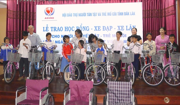 Người khuyết tật và trẻ mồ côi được nhận xe đạp, xe lăn nhân dịp Ngày Người khuyết tật Việt Nam.  
