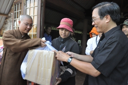 Ông Trương Minh Thắng, Tổng Biên tập Báo Dak Lak cùng Đại đức Thích Thi Tâm (Tịnh xá Tâm Đức) tặng quà các gia đình tại buôn Cuôr Kăp