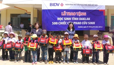 Đại diện hai cơ quan tặng áo phao cho trẻ