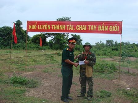 Đồng chí Đại tá Huỳnh Thanh Tịnh - Hiệu trưởng nhà trường tặng hoa và phần thưởng cho các học viên bắn đạt loại giỏi