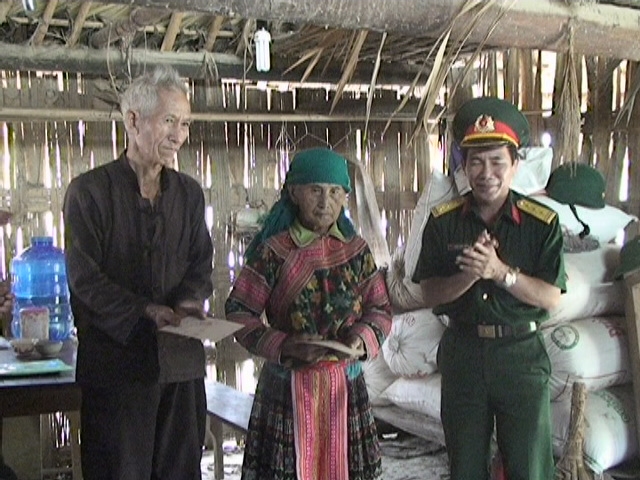 Đại diện Ban Chỉ huy Quân sự trao sổ tiết kiệm tặng gia đình ông Sùng Seo Thái.