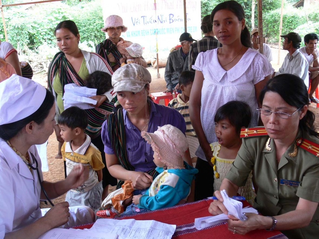 Thượng tá Nguyễn Thị Minh Vẻ (bìa phải) cùng với y bác sĩ khám bệnh, phát thuốc cho phụ nữ buôn Tu (xã Ea Tul, huyện Cư M'gar). 